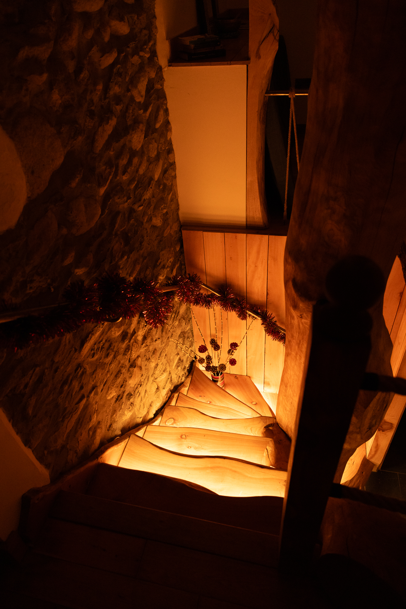 The handcrafted timber staircase warmly lit and decorated for Christmas