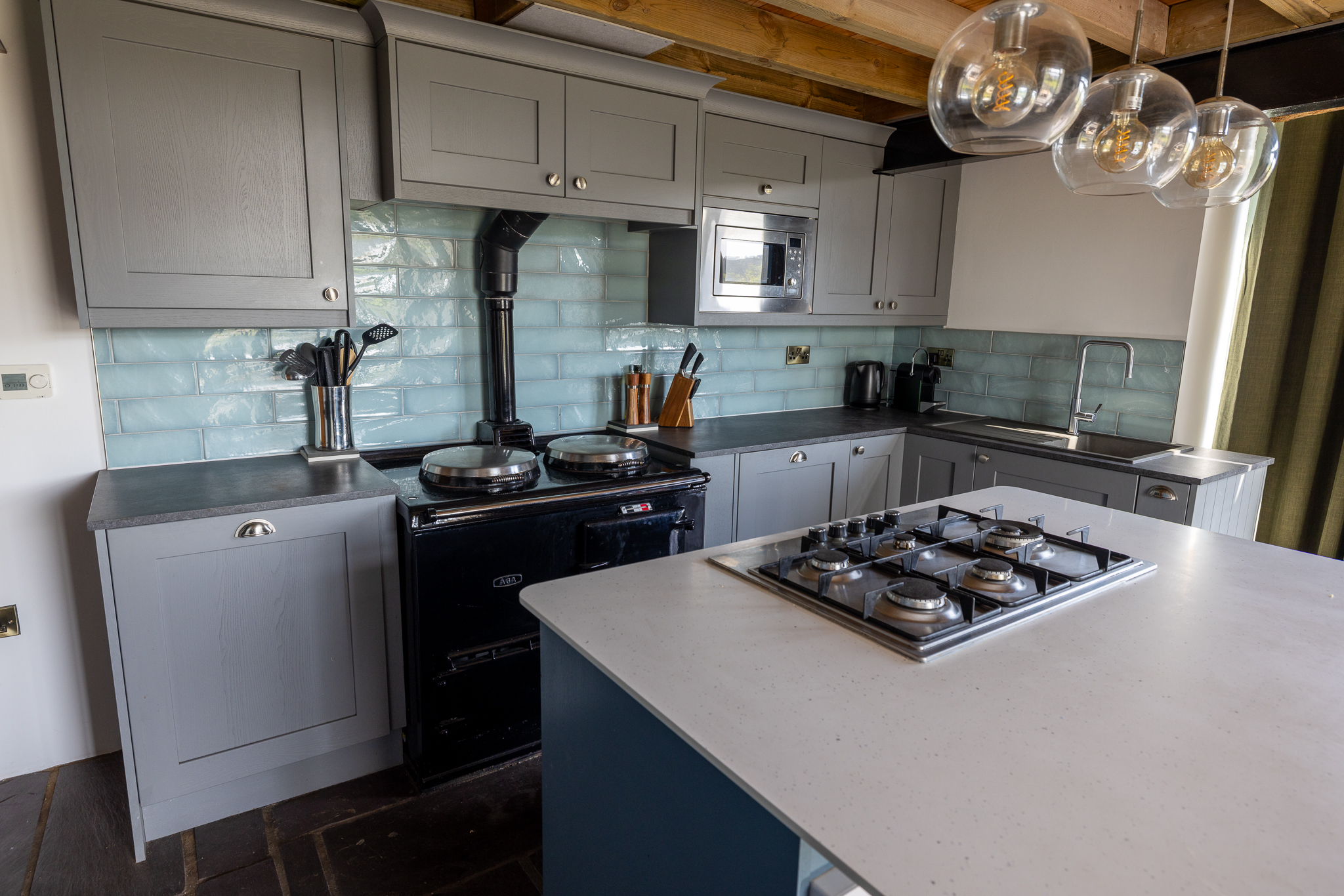 The cottage kitchen with an Aga and pale blue tiles