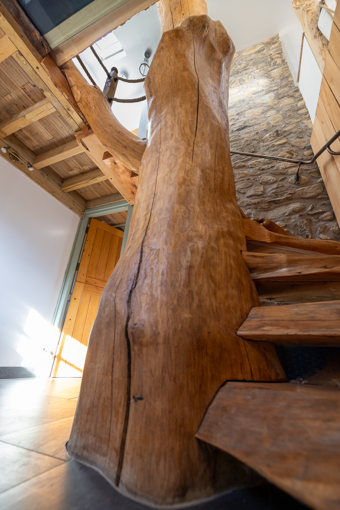 The sculptural handcrafted timber staircase inside Tree of Life Cottage