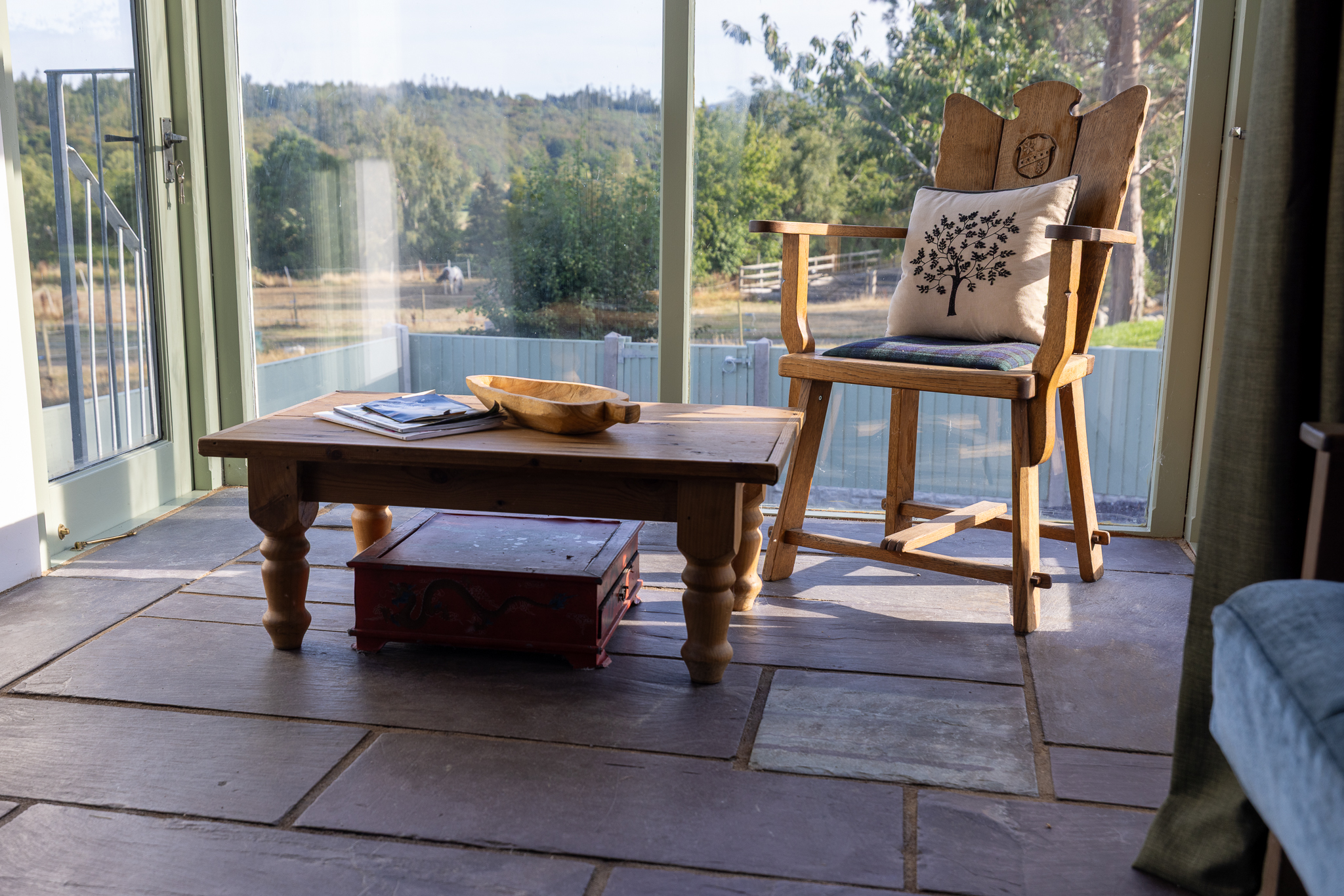 A handcrafted chair beside the cottage picture window